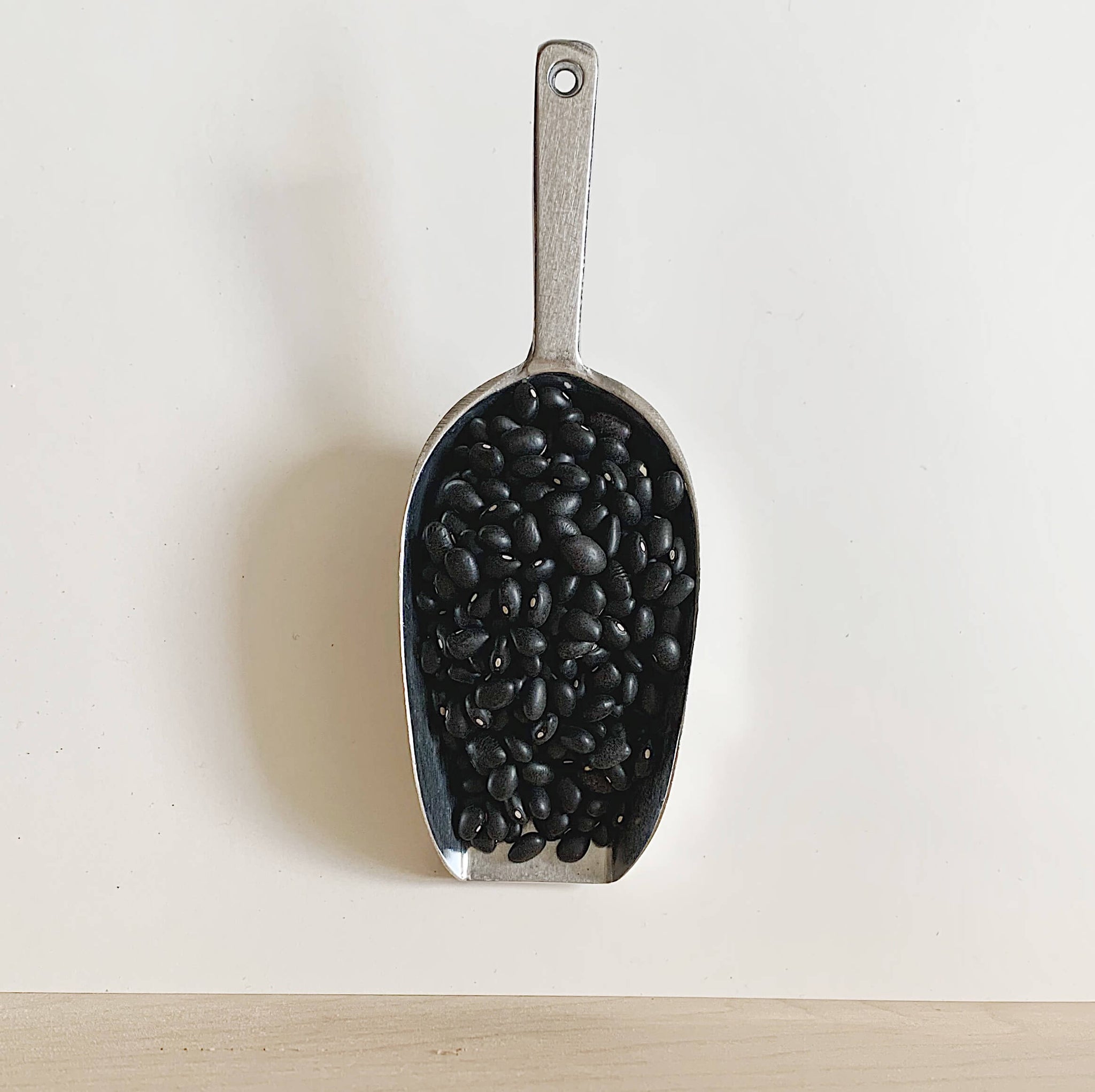 Close up of black beans on a metal scoop